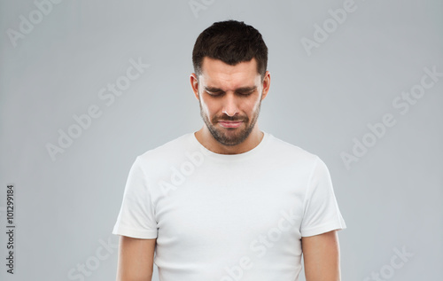 unhappy young man over gray background