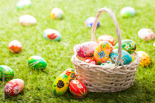 Unique hand painted Easter eggs in basket on grass