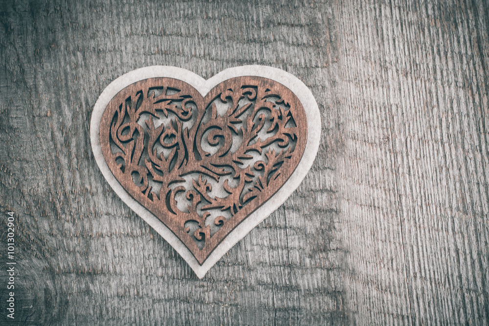 Fototapeta premium Valentines day wooden carved heart over wooden table background with copy space.