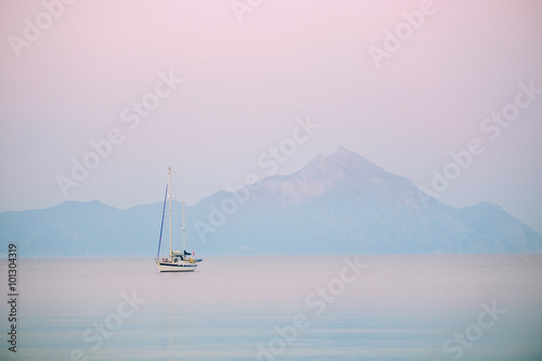 Yacht and blue water ocean with Athos mountain in the background - Greece, Europe