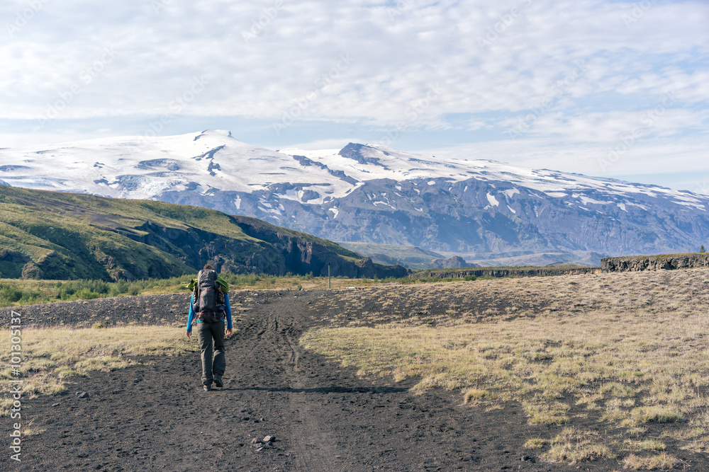 Female hiker walking Laugavegur trail in front of  Eyjafjallajökull volcano.