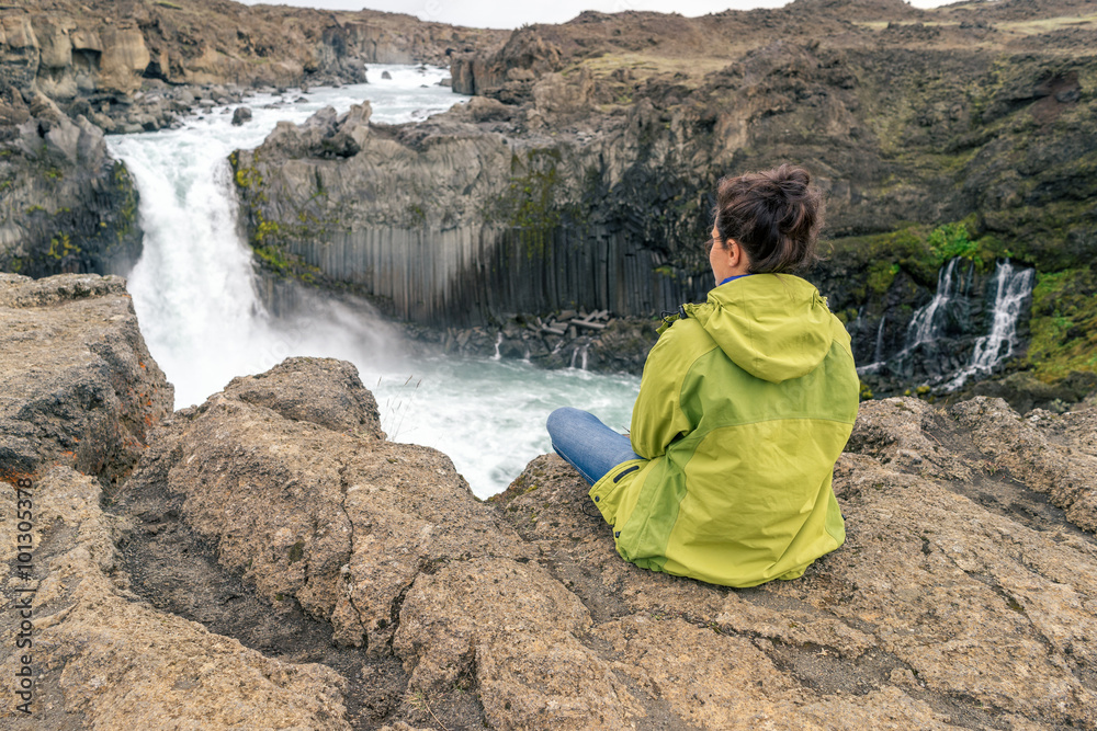 Fototapeta premium Female hiker sitting by Aldeyjarfoss waterfall, Iceland.
