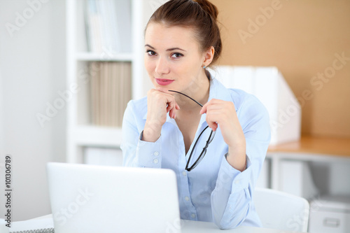 Young business woman working on laptop in office. Successful business concept. © rogerphoto