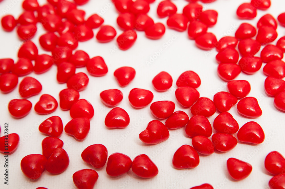 red cinnamon candy hearts on a white background with a shallow depth of field red cinnamon candy hearts on a white background with a shallow depth of field