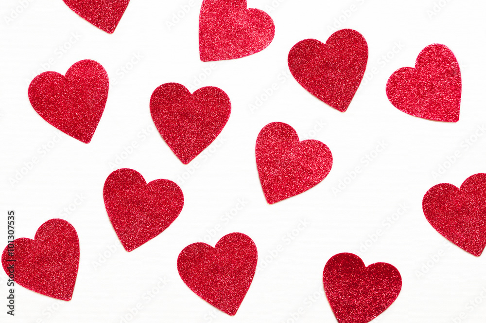 red glitter hearts on a white painters canvas background