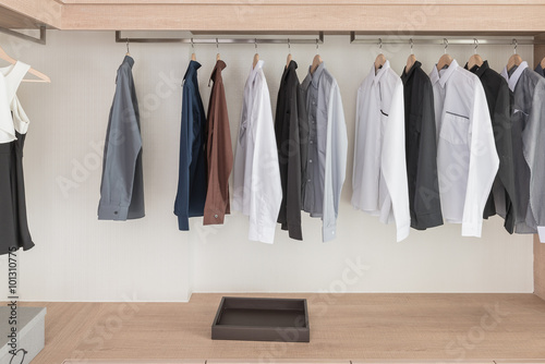 shirts hanging on rail in modern wooden wardrobe © 290712