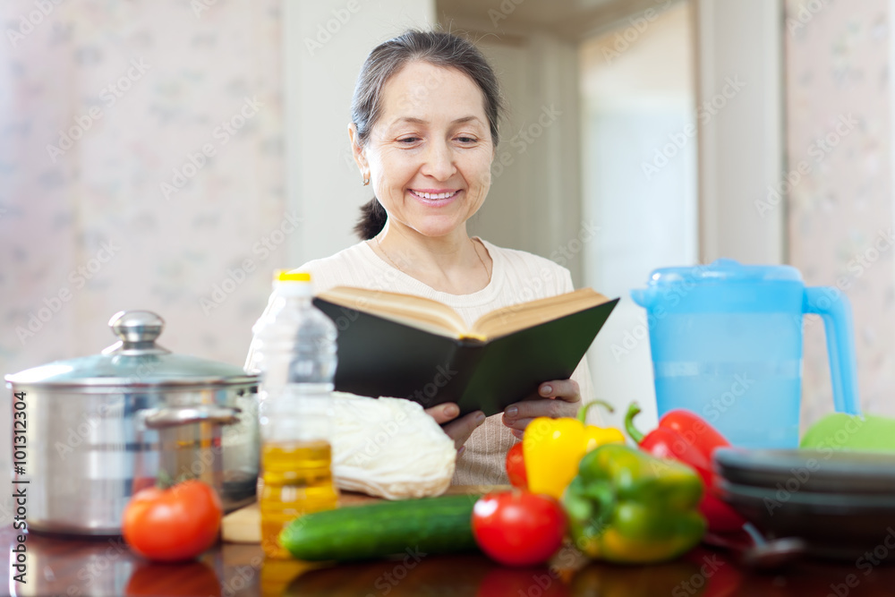 pensive  woman reads cookbook for recipe