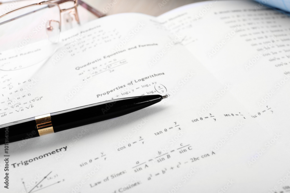 School supplies and textbook on mathematics close up School supplies and textbook on mathematics close up