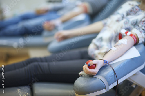 Woman donating bloo; hand with a ball in focus photo