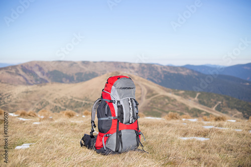 Red backpack standing on top of the mountain.