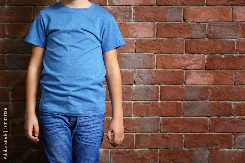 Small boy on brick wall background Small boy on brick wall background