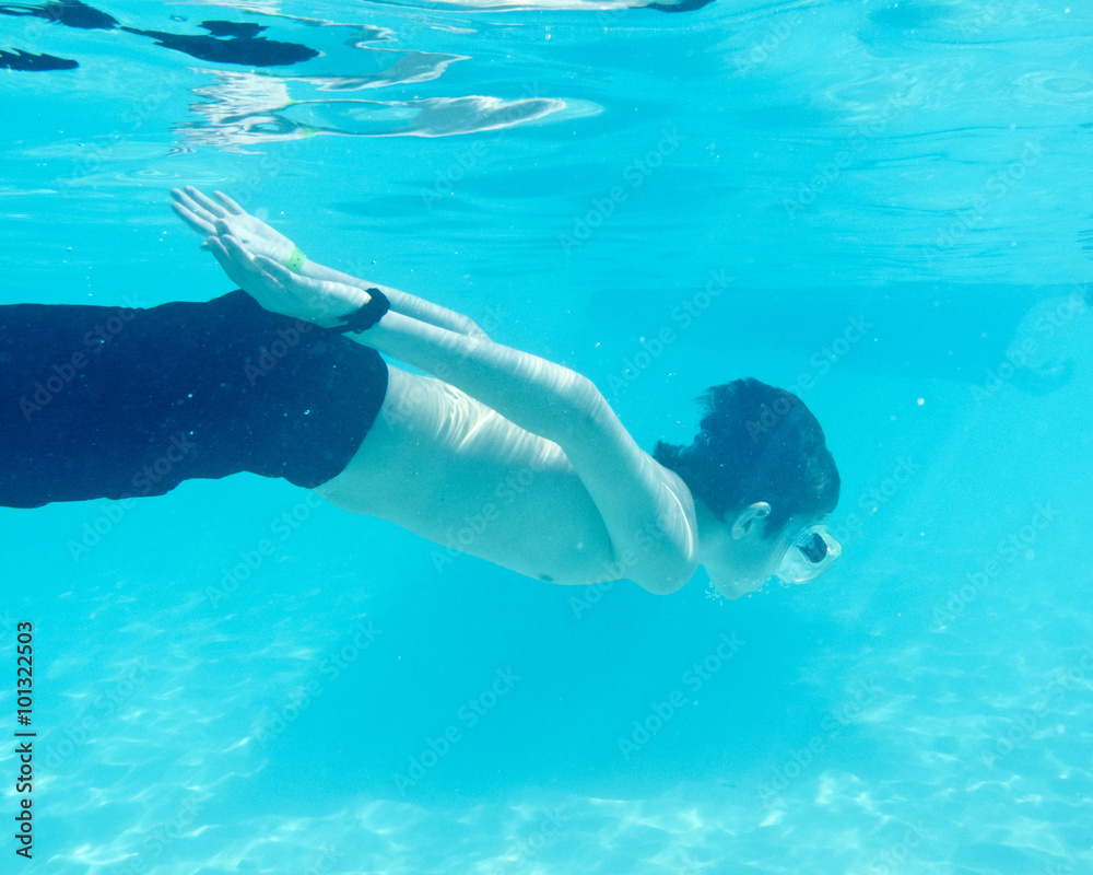 kid swimming underwater in ocean