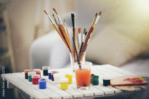 Drawing set with brushes and paints on white table