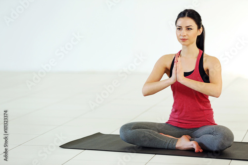 Young attractive woman does yoga in the class
