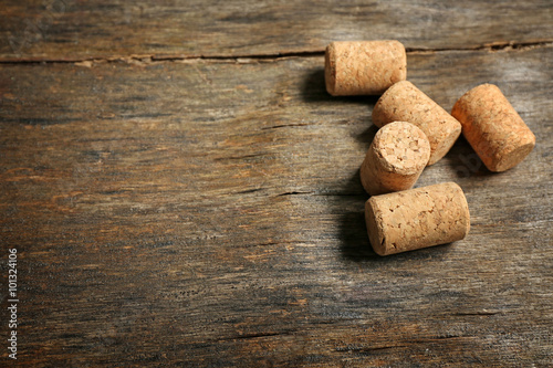 Five wine corks on old wooden background, close up