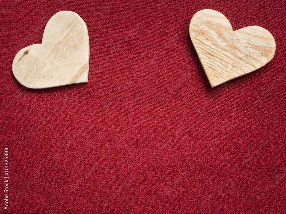 Fototapeta premium two wooden hearts on a red fabric background