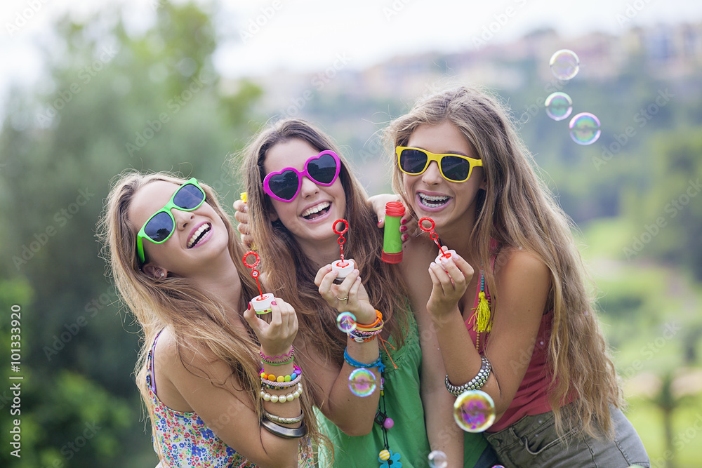 teen girls blowing bubbles - obrazy, fototapety, plakaty 