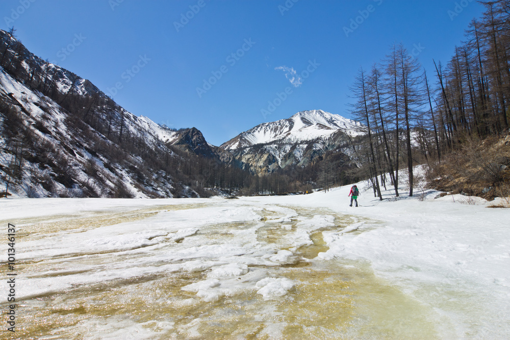 Mountain river yellow melts in the spring. A deep crack in the i