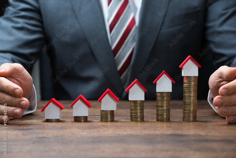Φωτογραφία Businessman Protecting House Models On Stacked Coins