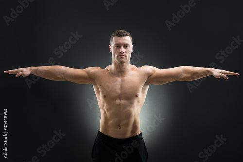 Confident Muscular Man Standing Arms Outstretched