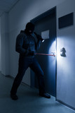 Thief With Flashlight Trying To Break Office Door