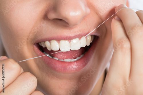 Woman Flossing Teeth At Home