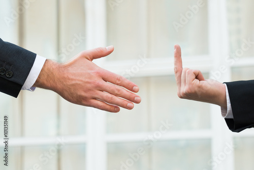 Businessman Showing Middle Finger To Partner Offering Handshake