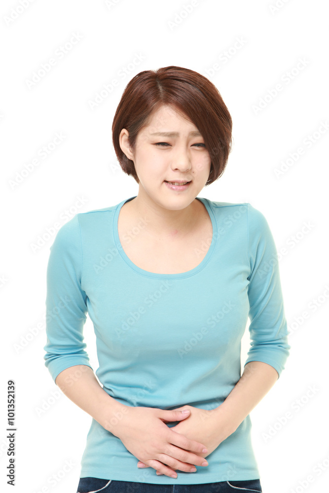 young Japanese woman suffers from stomachache young Japanese woman suffers from stomachache