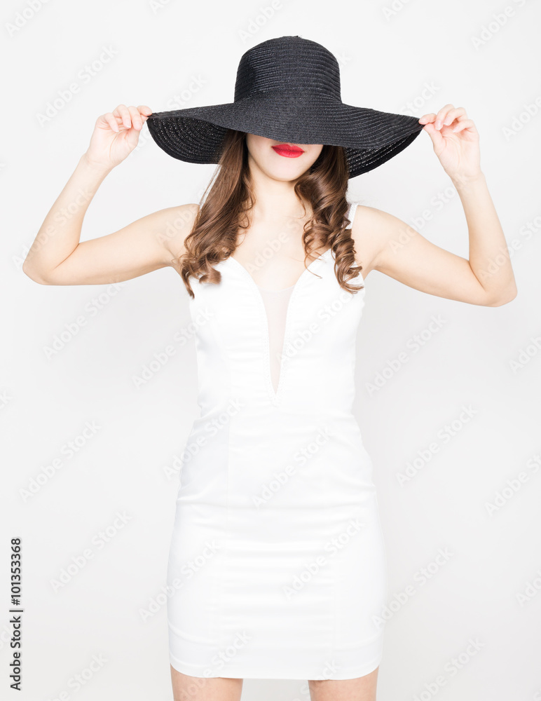 Beautiful sexy slim woman in a little white dress and broad black hat Beautiful sexy slim woman in a little white dress and broad black hat