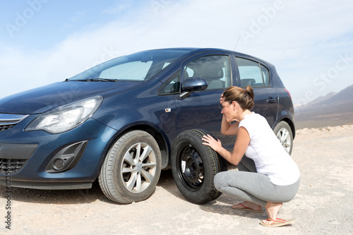 Frau beim Reifenwechsel