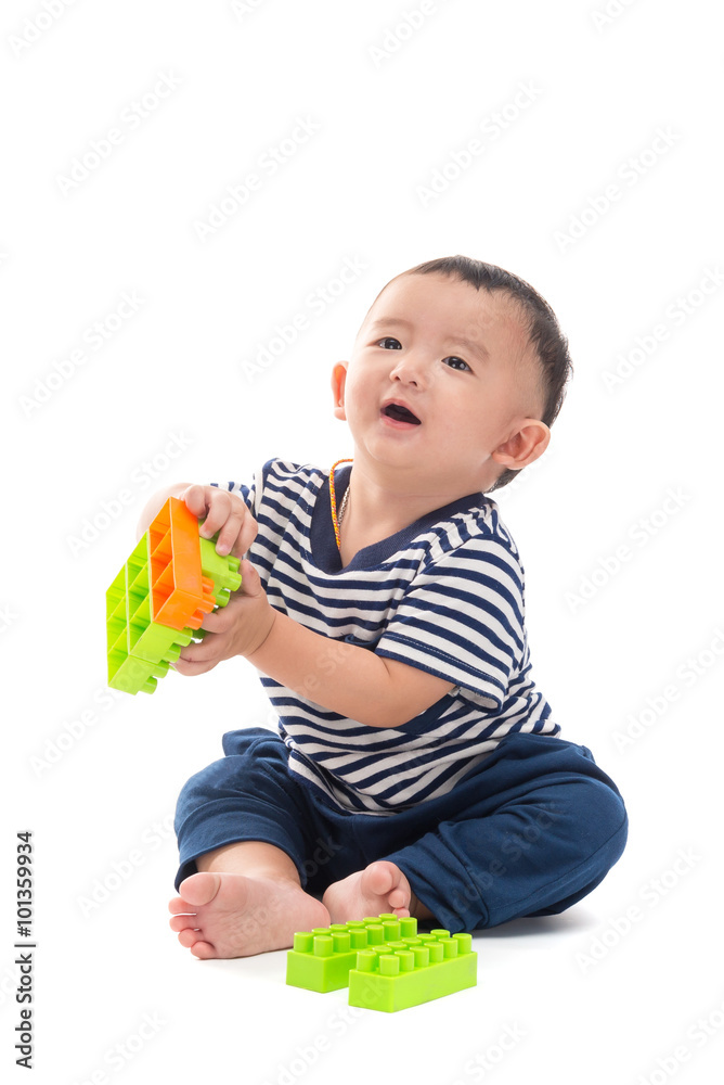 Asian baby is playing with plastic construction toys over white Asian baby is playing with plastic construction toys over white