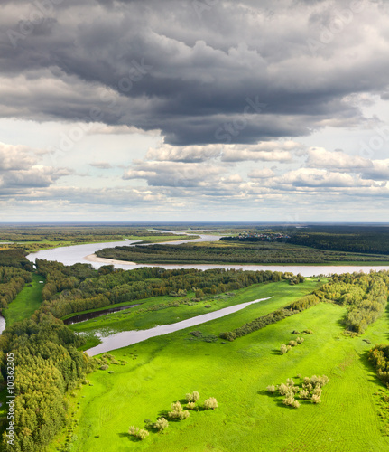 Top view of green forest meadow near the river