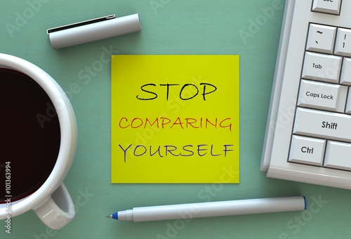 STOP COMPARING YOURSELF, message on note paper, computer and coffee on table