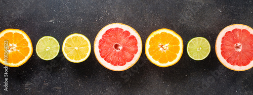 Slika na platnu Mix of citrus fruits on dark table