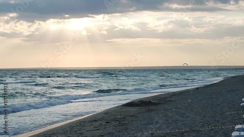 Evening sea and sun. Black Sea in the evening hours. Empty beach with sun beds, lined up. Panorama extends the horizon and clouds. Ukraine, Crimea, Donuzlav July 29, 2013, the Black Sea photo