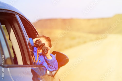 happy little boy travel by car in mountains