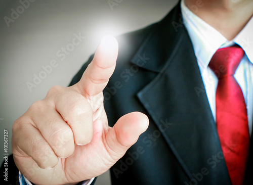 man in suit showing gesture point something on gray background.