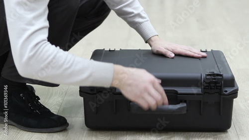 Man opening plastic case with photo things and unpacking photo