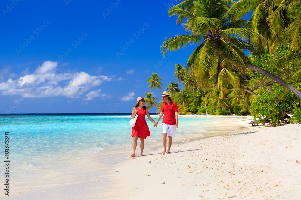 happy loving couple walking on summer beach