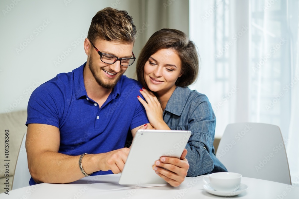 Cheerful couple behind table at home Cheerful couple behind table at home