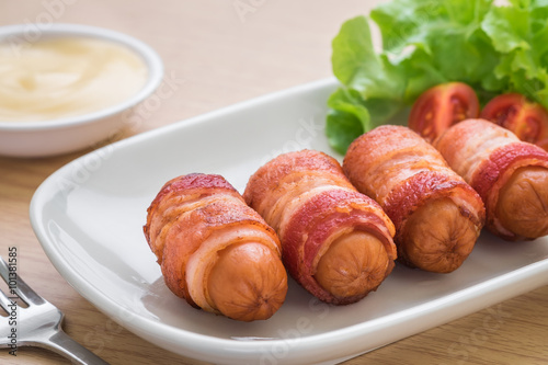 Sausages wrapped with bacon and dipping sauce