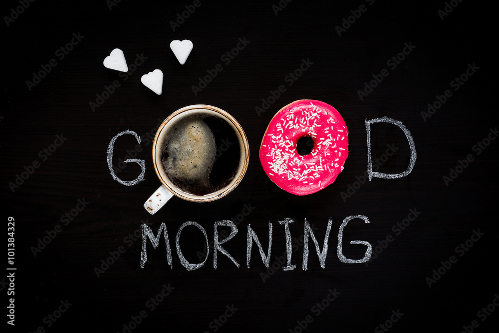 Donut, cup of coffee and heart shaped sugar cubes. Good morning greeting written on black chalk board. Table top view. Breakfast food concept. Valentines day Donut, cup of coffee and heart shaped sugar cubes. Good morning greeting written on black chalk board. Table top view. Breakfast food concept. Valentines day