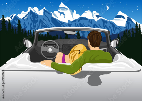 couple sitting in white convertible car hugging and looking at the mountains under the night sky 