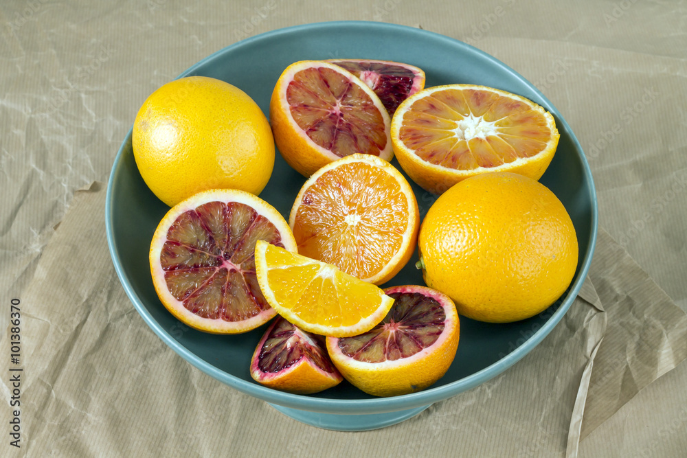 Fresh whole and sliced oranges lying on gray paper. Fresh whole and sliced oranges lying on gray paper.