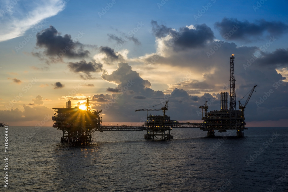 Offshore oil rigs or production platforms during sunset Offshore oil rigs or production platforms during sunset