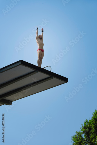 High diving competitor, standing on platform, preparing to dive