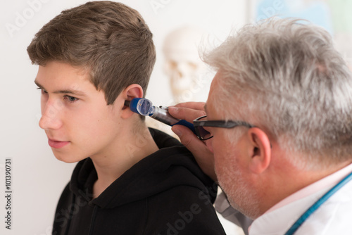 Arzt leuchtet ins Ohr eines Patienten