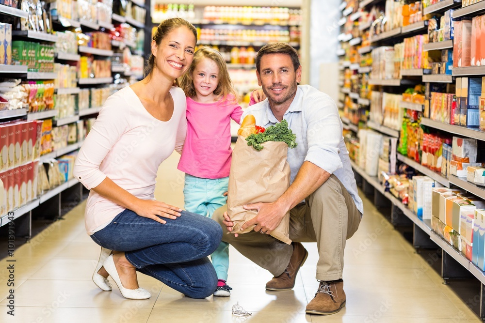 Smiling family with grocery bag at the supermarket