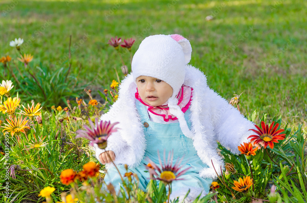 The child, a little girl sitting in a bed and looks flowers The child, a little girl sitting in a bed and looks flowers
