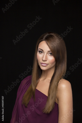 portrait of a beautiful brown-haired girl. The woman puts her hair, using lacquer, natural color